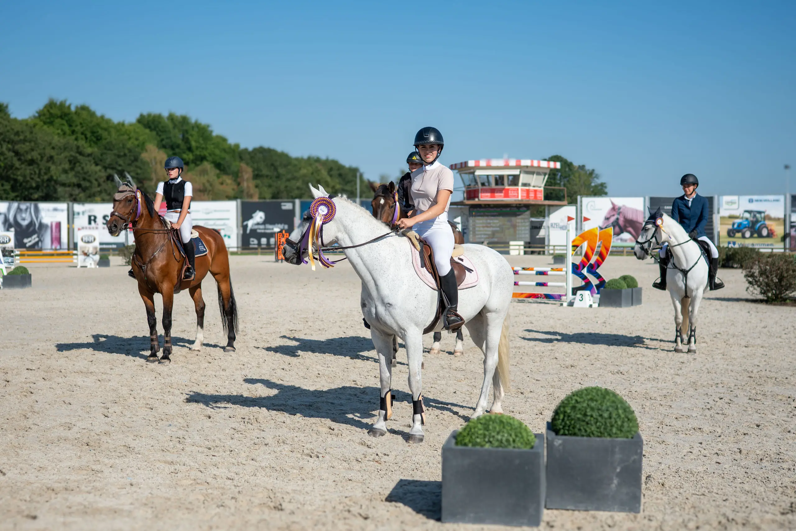 Ruiters op de losrijpiste van Azelhof onder een blauwe lucht