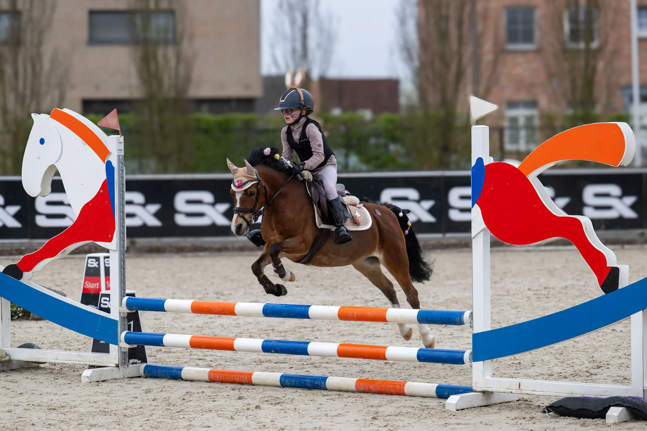 Pony springt over een kleurrijke hindernis op Sentower Park